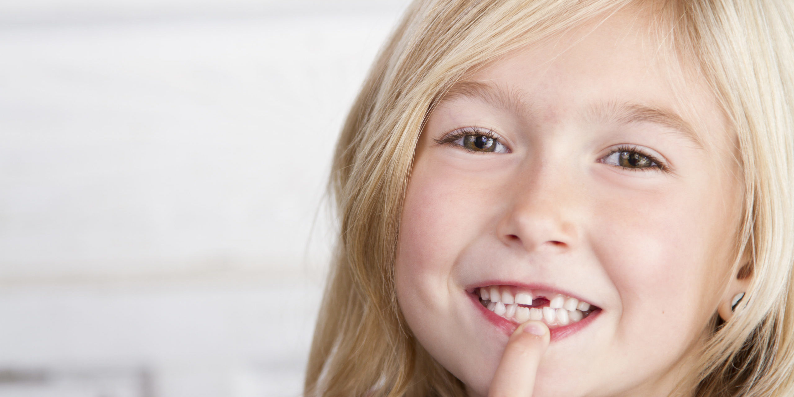 Child,Missing,Front,Tooth,Pointing,At,It,With,Her,Finger